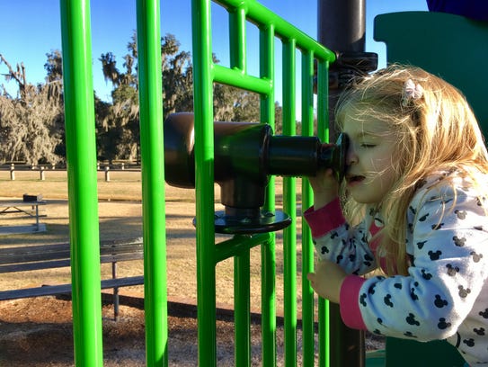 Avery Guidry, 3, looks through a toy telescope attached