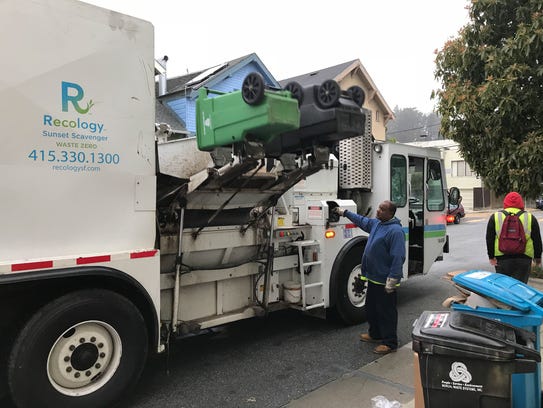 A Recology recycling truck picks up waste and mixed
