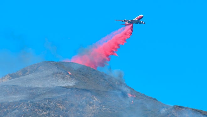 An aircraft drops retardant over  burning embers and small fires on top of a mountain in Fillmore, Calif., on December 8, 2017.
ires in the Los Angeles area and new outbreaks near San Diego. / AFP PHOTO / FREDERIC J. BROWNFREDERIC J. BROWN/AFP/Getty Images ORIG FILE ID: AFP_V02EM