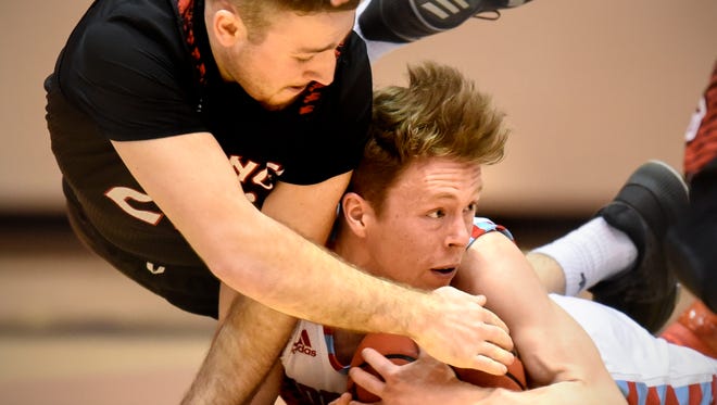 Garrett Goetz of St. John's tries to hang onto a loose ball against Daniel Gutzmer of Bethany Lutheran Friday, March 2, during the first round of the NCAA Division III Men's Basketball Championship at St. John's University in Collegeville.