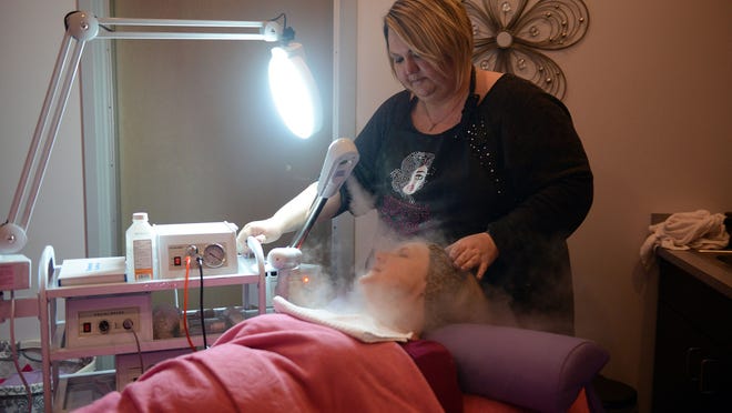 Jennifer Garlock, the owner of Sweet Cheeks Skin Spa, uses a steam treatment on a customer at her new space in the Sutton Center in Port Clinton.