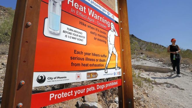Signs waring of extreme heat are placed on a trailhead, Wednesday, June 22, 2016, at Piestewa Peak in Phoenix.