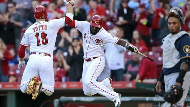 Joey Votto and Brandon Phillips do a leaping high-five as Votto crossed the plate on a solo home run last night.