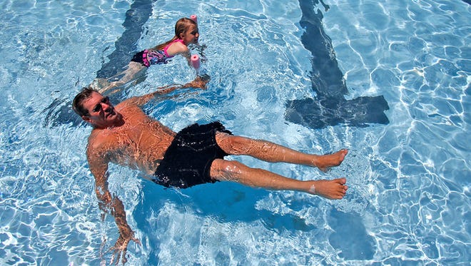 Paul Lehrman and his daughter, Jessie Lehrman, swim on May 30, 2015, at Brookside Pool in Farmington.