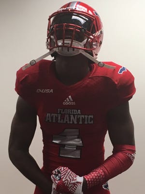 West Florida linebacker Antarrius Moultrie reacts to trying on a Florida Atlantic uniform and committed to FAU on Thursday.
