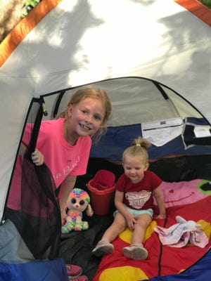 Kate Gillum and sister Claire play in a tent. Kate's heart went into an abnormal heart rate that had it beating 225 beats per minute in April.