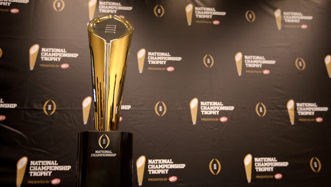 This Monday, July 14, 2014 photo shows the College Football Playoff National Championship Trophy in Irving, Texas. A rising gold football-shaped trophy will be the prize for the national champion in the new College Football Playoff.