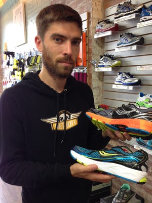 Justin Craig, co-owner of the RunDetroit store,  shows two different types of running shoes.  On top is a Saucony Guide 7 stability shoe for motion control. The other shoe, a Saucony Ride 7, is for  a neutral foot.