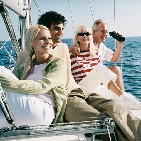 Four people on a sailboat at sea.