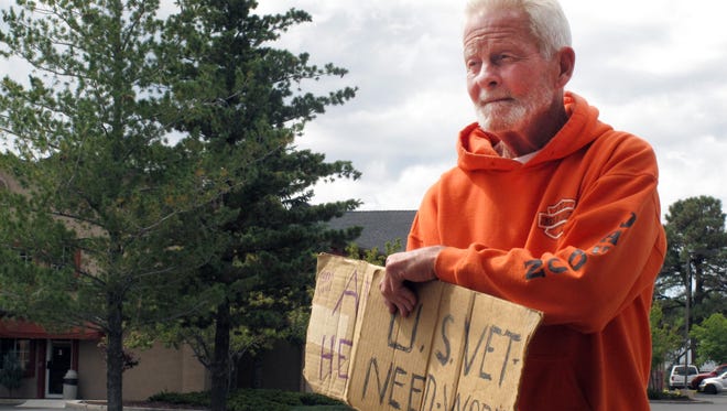 Richard Russler, 77, stands on a corner in Flagstaff, Ariz., on Tuesday, Sept. 17, 2014 asking passers-by for financial help. The Flagstaff Police Department has introduced a voucher program to discourage people from giving cash to panhandlers.