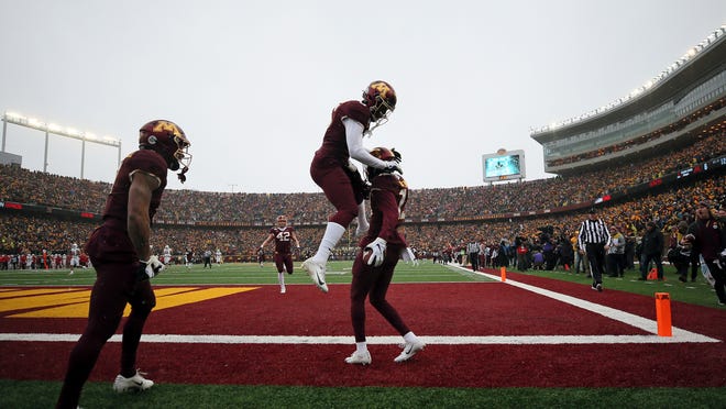 Minnesota wide receiver Tyler Johnson (6) jumps up in the air to celebrate with teammate wide receiver Rashod Bateman (13) after Bateman scored a touchdown against Wisconsin during an NCAA college football game Saturday, Nov. 30, 2019, in Minneapolis. (AP Photo/Stacy Bengs)