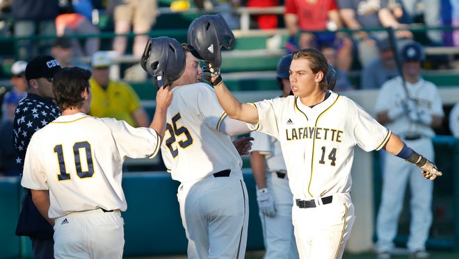 Mark Sluys of the Lafayette Aviators is greeted at home plate by teammates Bryce Evans and Evan Kennedy after hitting a three-run homer in the bottom of the fourth inning against the Danville Dans Friday, July 1, 2016, at Loeb Stadium. 