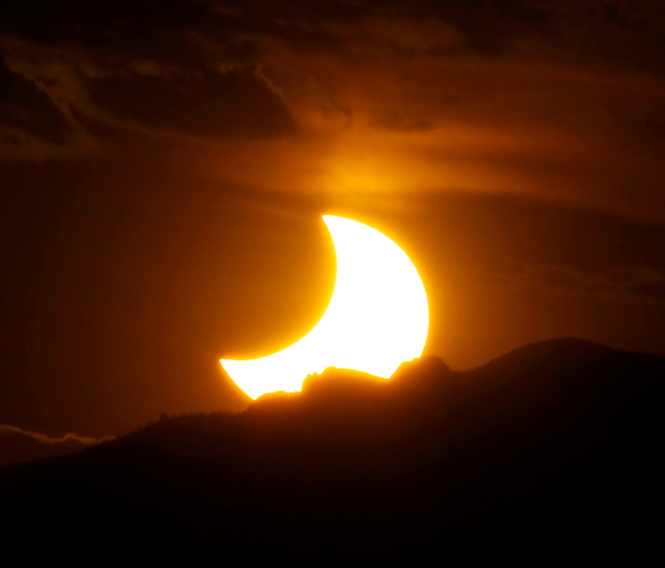 File photo shows 2012 solar eclipse in Denver. The 2017 eclipse will cover a large swath of the continental U.S. and travelers are clamoring to get into its path.