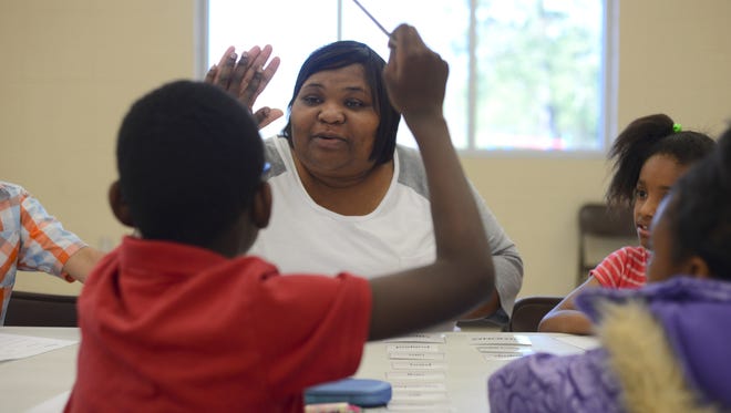 Teacher Jameica Wilson high-fives a third-grader at Grace Christian School during a Boost Camp held to help students prepare for the third-grade reading assessment. Hattiesburg Public School District had the lowest pass rate in Forrest and Lamar counties: 77.2 percent.