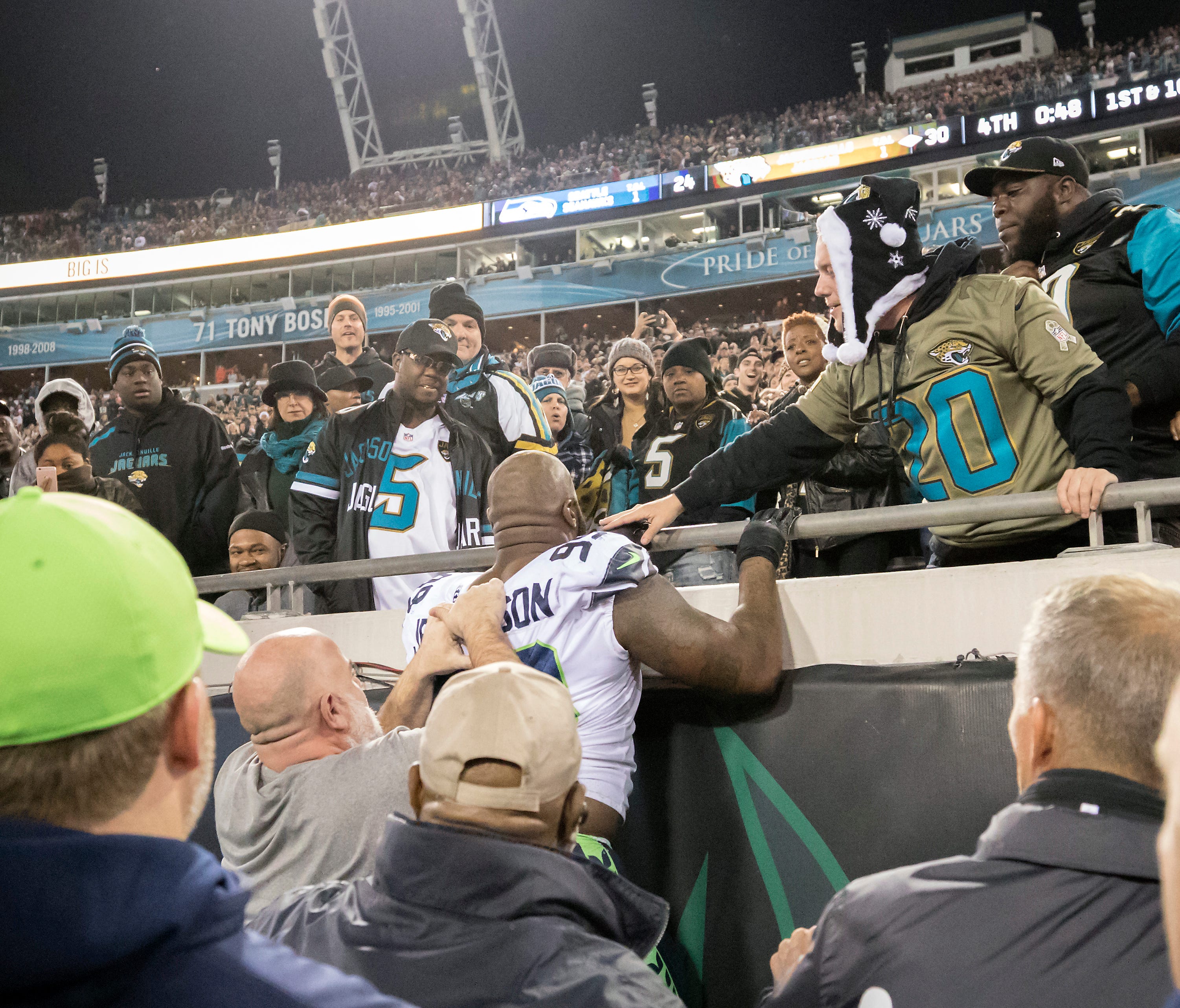 Seattle Seahawks DT Quinton Jefferson tries to climb up in the stands after Jacksonville Jaguars fans threw objects at him.