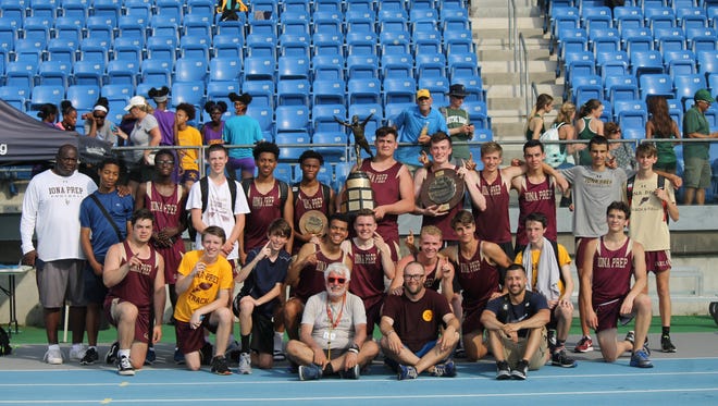 Coach Jan Mitchell (sitting, light T-shirt), other Iona Prep coaches and the 2018 champion Gaels