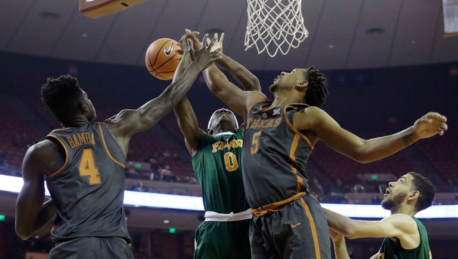 Florida A&M forward Desmond Williams (0) is blocked by Texas forward Royce Hamm Jr. (5) as he tries to score during the first half of an NCAA college basketball game, Wednesday, Nov. 29, 2017, in Austin, Texas.