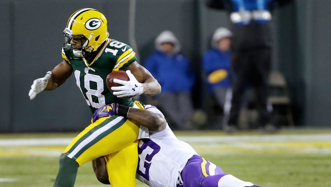 Green Bay Packers wide receiver Randall Cobb fights for more yards as Minnesota Vikings cornerback Xavier Rhodes tries to make the tackle at Lambeau Field.