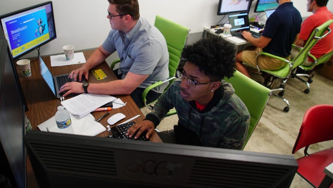 (right)Nazhir Jackson, lead developer, works next to Jim Jannuzzio, a University of Delaware student who founded BookBandit in 2016 to make the textbook buying process more affordable and convenient for college students. The free BookBandit app helps students find textbooks at the lowest price available from reputable online vendors.