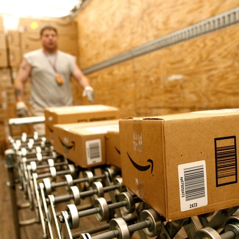 Amazon worker loading Amazon boxes on a conveyor b