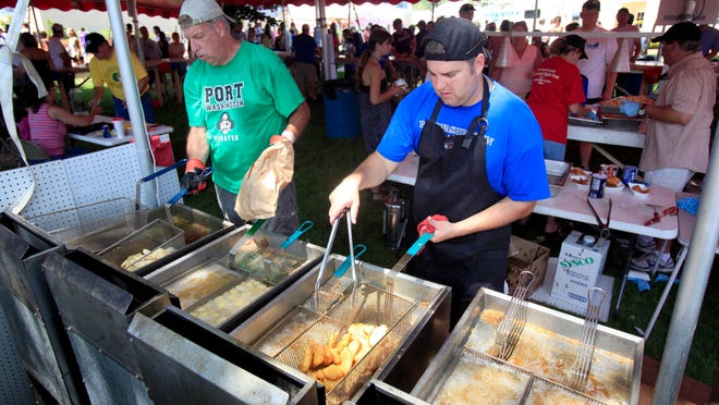 Geno Fidler, left, and Joe Eernisse fry shrimp and cod at a previous Port Fish Day. The popular event was canceled this year due to the coronavirus.