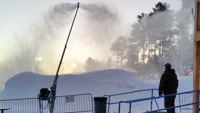 A silhouetted Sheldon Sturtevant oversees snowmaking at the Winter Park snow play area in Ruidoso.