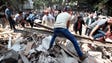 People remove debris of a building which collapsed
