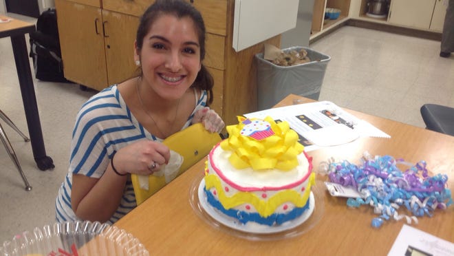 Scott High School junior Angie Paden shows a finished decorated layer cake in the “Art of Baking” class.