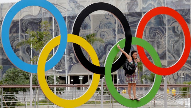 A volunteer stands on the Olympic rings as she poses for a picture days ahead of the opening ceremony in Rio de Janeiro.