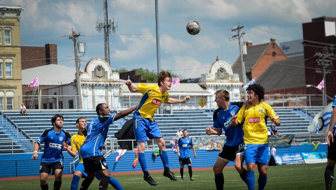 The Saints compete against Buffalo FC last year at Taft High School. Downtown and Music Hall can be seen in the background.