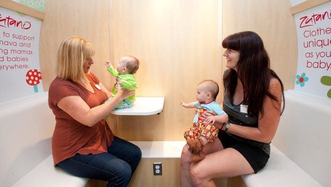 Maggie Lindsay, left, holds 4-month-old Cassie alongside Nikki Dryden and 5-month-old Eloise, all of Burlington, Vt., while exploring a new Mamava lactation station Aug. 29, 2013, at Burlington International Airport.