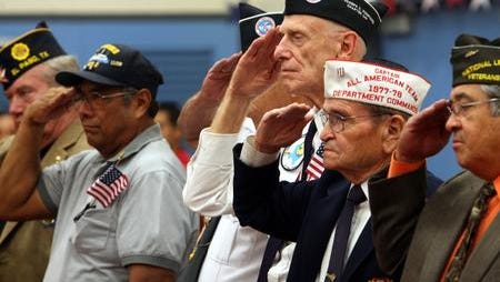 El Paso military veterans, including Manuel Rivas, second from right, saluted during presentation of the colors at the MacArthur school Veteran's Day ceremony in this file photo from 2008,