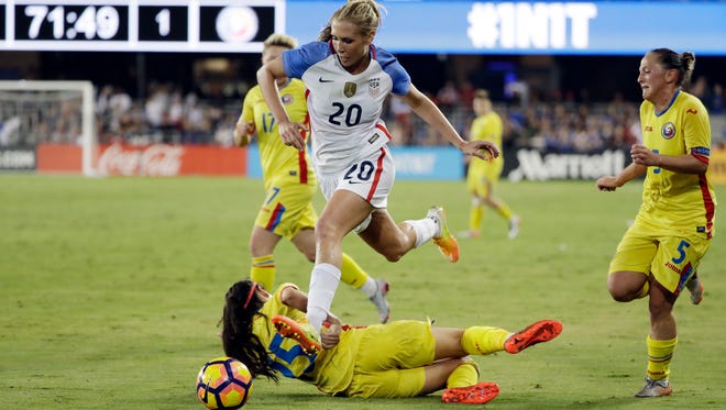 In this Nov. 10, 2016, file photo, United States' Allie Long, top, leaps over Romania's Teodora Meluta during the second half of an exhibition soccer match in San Jose, Calif.