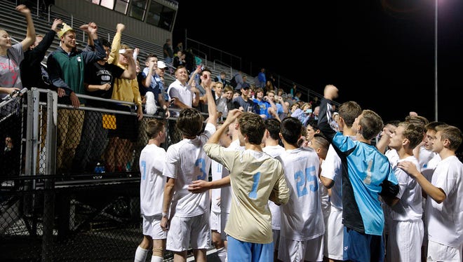 Lansing Catholic players celebrate with fans following their upset win over top-10 ranked Williamston Wednesday, Oct. 19, 2016, in Lansing, Mich.