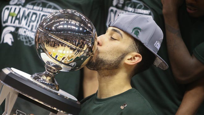 Michigan State's Denzel Valentine kisses the Big Ten tournament trophy Sunday, March 13, 2016 in Indianapolis.