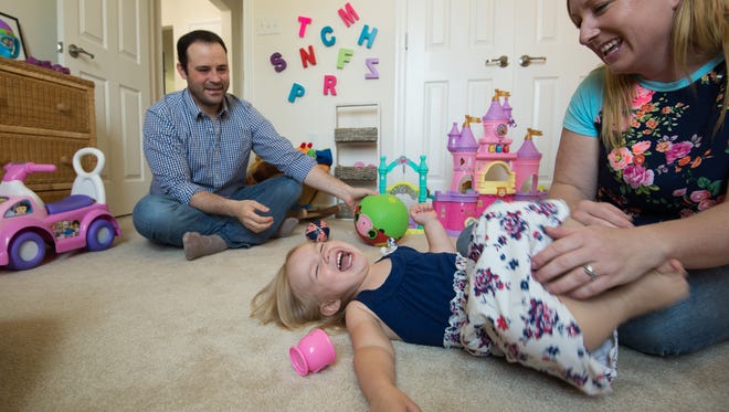 Steven Callahan and his wife Ragan play with their daughter Quinn, 2, at their home in Milton.