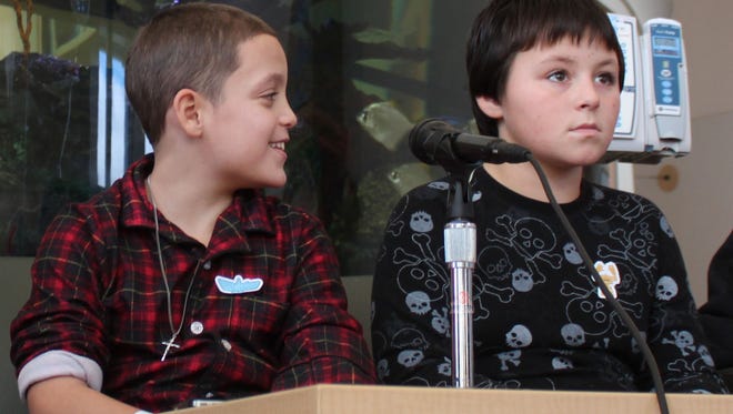 Nine-year-old Jason Rivera, left, and Elijah Martinez, 11, appear at a news conference, Friday, Nov. 28, 2014, at Westchester Medical Center's Maria Fareri Children's Hospital in Valhalla, N.Y. The boys spent seven hours trapped in the snow the night before until an alert police officer saw a shovel half buried and started to dig. (AP Photo/Times Herald-Record, Leonard Sparks)
