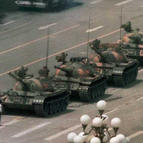 A Chinese man stands alone to block a line of tank