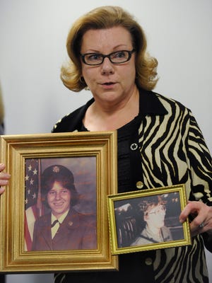 Lucy Nichols holds photos of her murdered sister Julia Lindsey following the parole hearing of the three men convicted of the murder, Ben Oryang, Tyrone Gibson & McArthur Harris, in Montgomery, Ala. on Wednesday February 11, 2015. The three were denied parole.