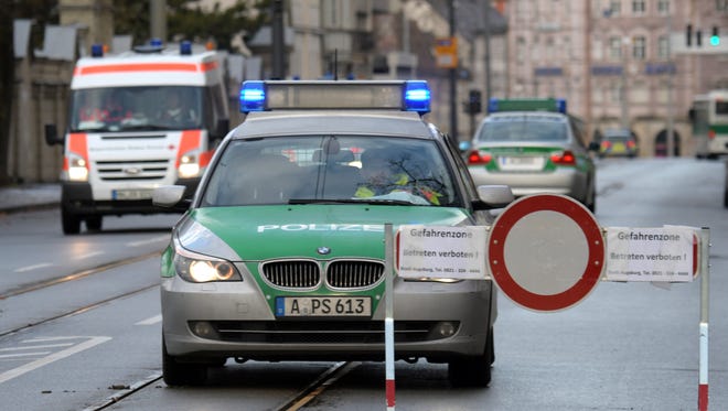A police vehicle driving through the deserted streets of the inner-city of  Augsburg, Germany, Sunday Dec.25, 2016. Thousands of people in the German town of Augsburg have temporarily left Christmas presents and decorations behind while authorities disarm a World War II bomb. The bomb was uncovered last week during construction work.