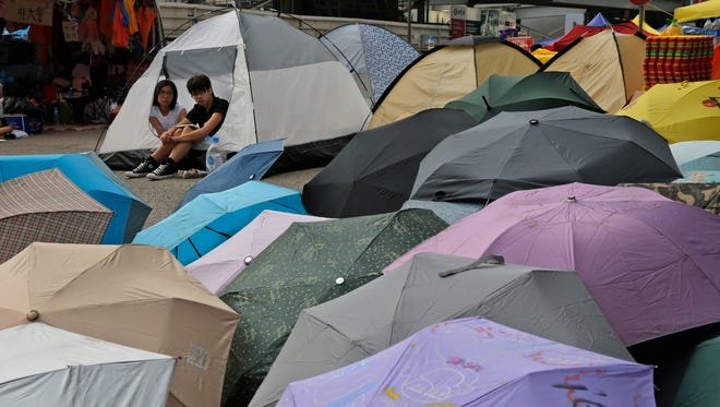 Protesters sit next to an umbrella installation on a main road in the occupied areas outside government headquarters in Hong Kong's Admiralty district on Oct. 9, 2014.