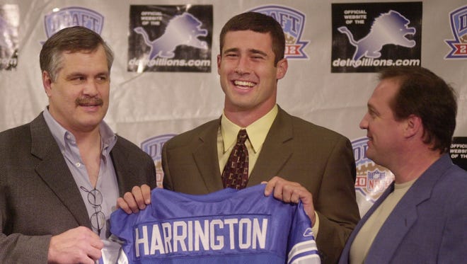 Lions president and chief executive officer Matt Millen, left, and head coach Marty Mornhinweg, right, pose with the team's first-round draft pick, Oregon quarterback Joey Harrington, on  April 21, 2002, at the Lions practice facility in Allen Park.