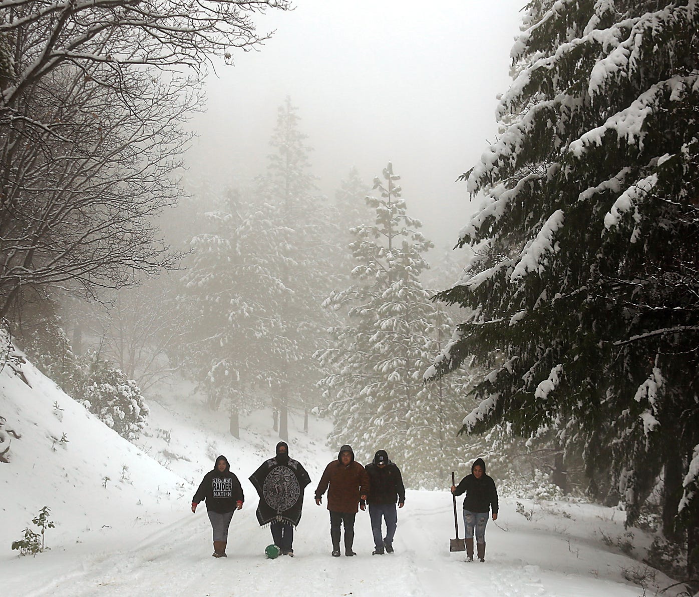 A group of friends from Clearlake, Calif., look for a favorable sledding hill in the Mendocino National Forest, Calif., on Jan. 3, 2017.
