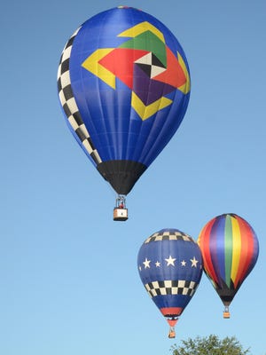 Brandon Bloom in his new balloon, Royal Racer, leads two other pilots, AJ Nels, rear from left, and Dominic Bareford, to a target Sunday.