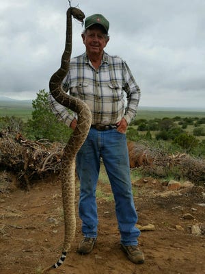 Russell Burris is pictured with the large rattlesnake he helped kill Aug. 10.