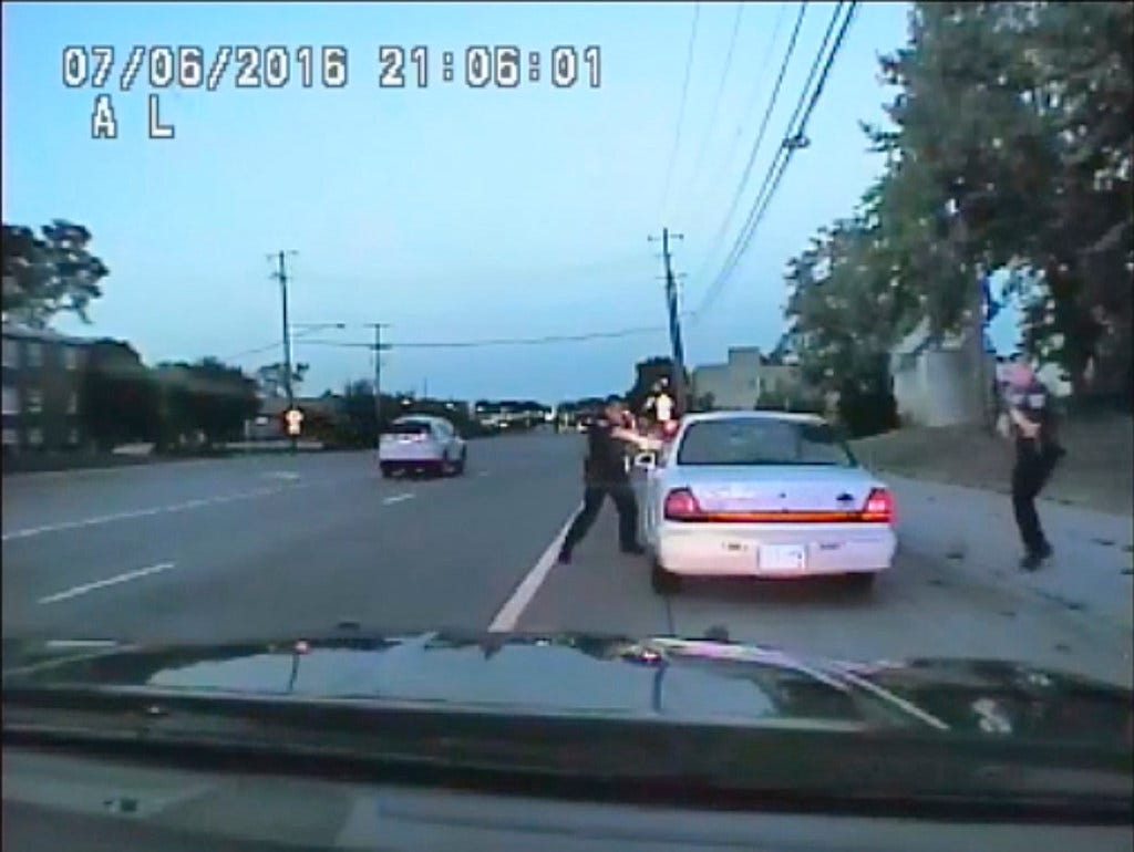 In this image made from July 6, 2016, video captured by a camera in the squad car of St. Anthony Police officer Jeronimo Yanez, the Minnesota police officer shoots at Philando Castile in the vehicle during a traffic stop in Falcon Heights, Minn. Yane