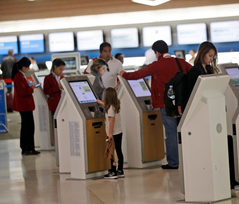 Travelers check in at kiosks at San Francisco International Airport on Nov. 22, 2015.
