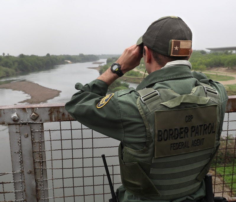 A U.S. Border Patrol agent scans the Mexico border of the Rio Grande.