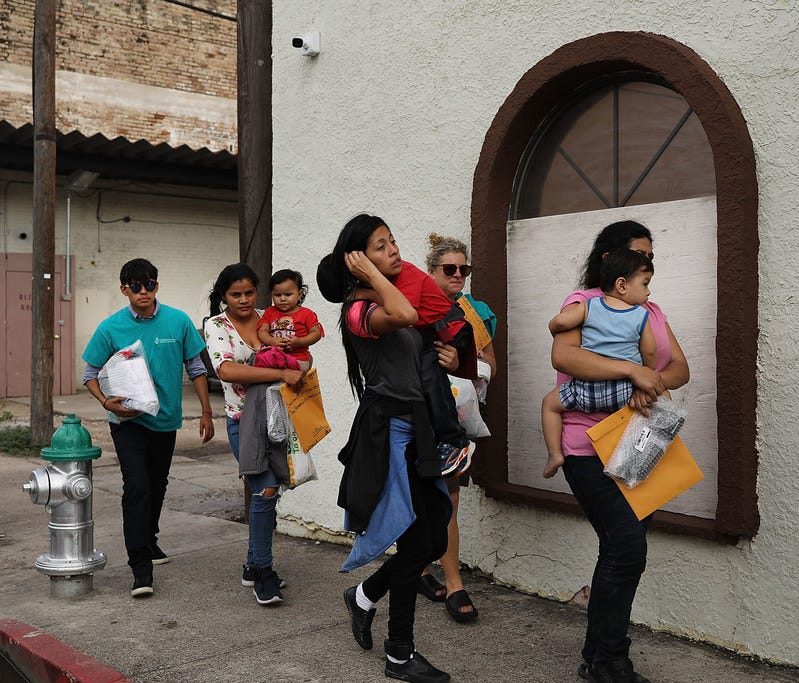 Migrants released from border detention in McAllen, Texas, walk to a relief center on June 22, 2018.