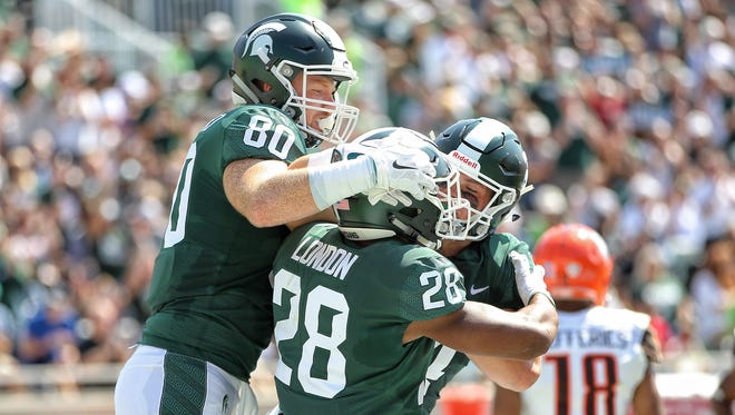 Sep 2, 2017; East Lansing, MI, USA; Michigan State tight end Matt Seybert (80) and running back Madre London (28) celebrate a touchdown in the first quarter against Bowling Green at Spartan Stadium.